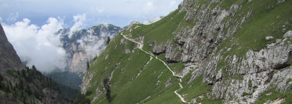 The AV9 slopes up a hillside to a cross, on the way to the Tires hut